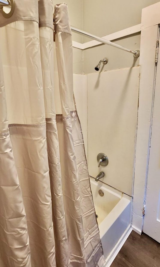 bathroom featuring wood-type flooring and shower / bath combination with curtain