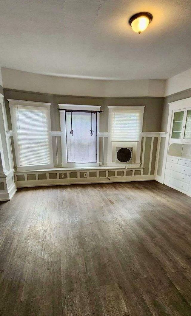 unfurnished living room with wood-type flooring and a textured ceiling