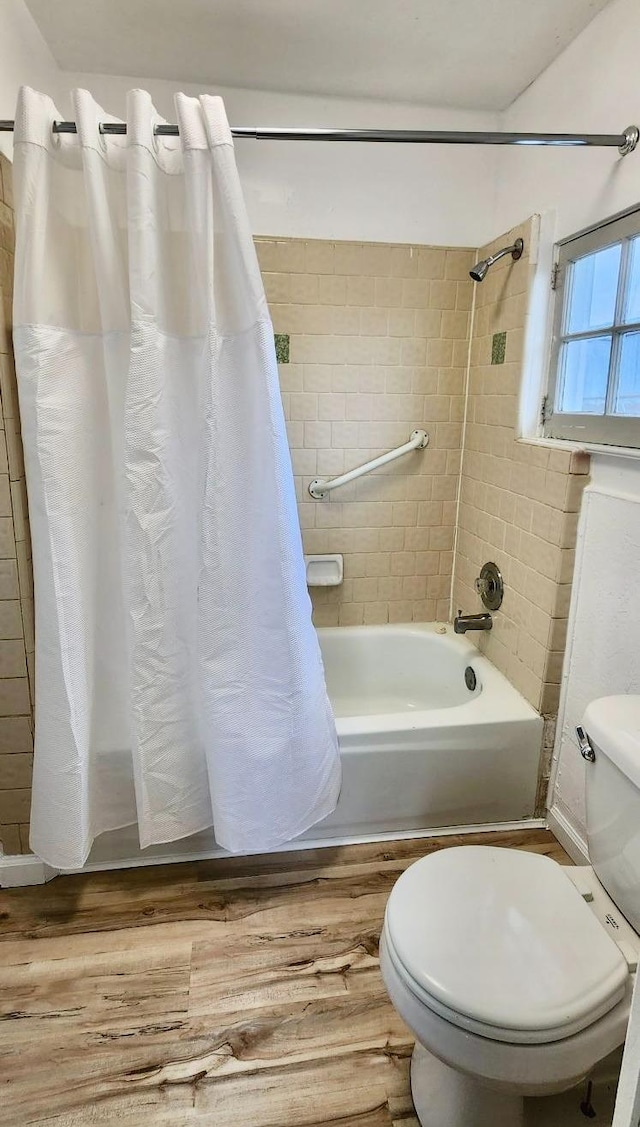 bathroom with wood-type flooring, shower / tub combo, and toilet