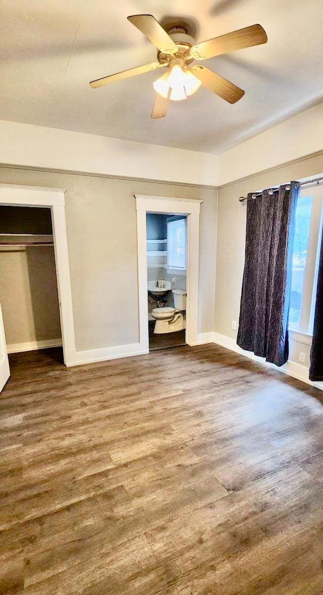 unfurnished bedroom featuring ceiling fan, wood-type flooring, and a closet