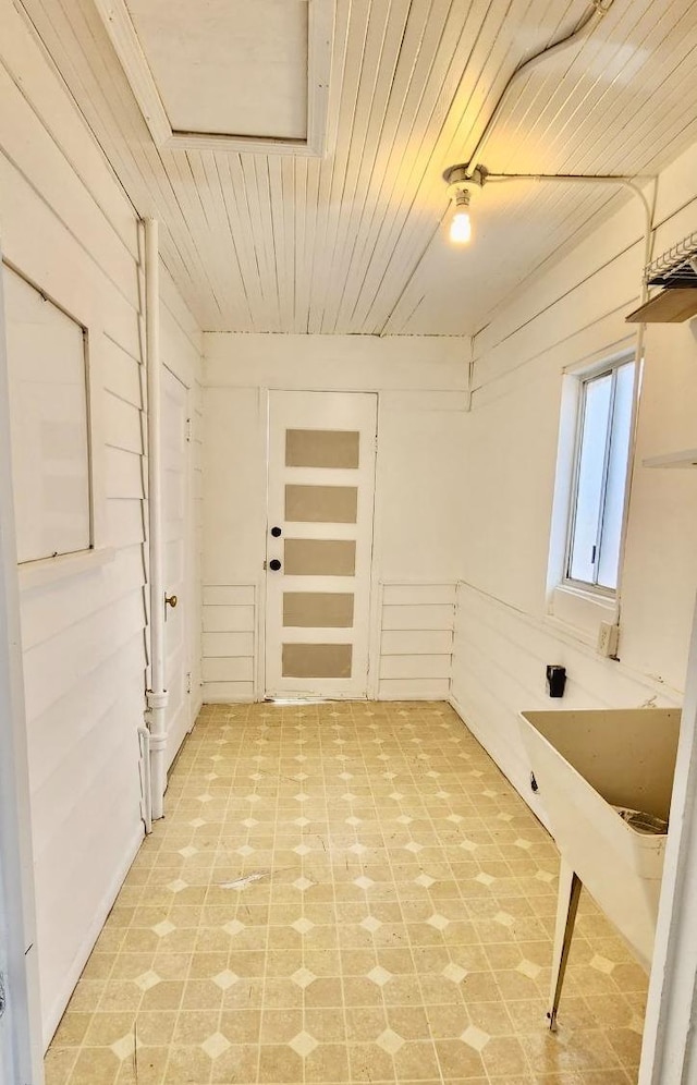 laundry area with wooden walls and wood ceiling