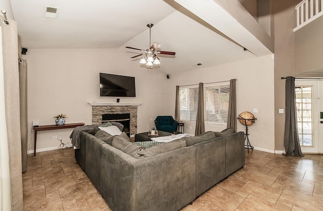 living room featuring high vaulted ceiling, a stone fireplace, and ceiling fan