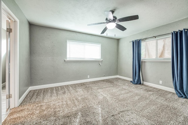 carpeted empty room featuring ceiling fan, a healthy amount of sunlight, and a textured ceiling