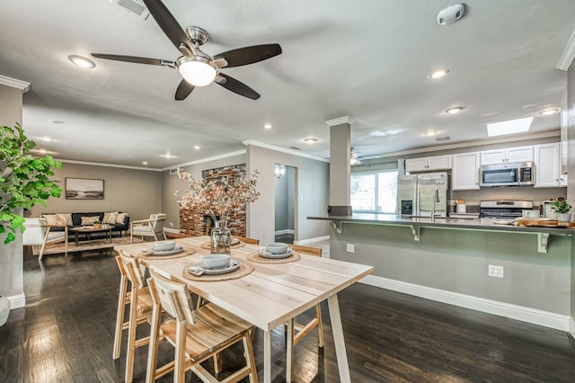 dining area featuring crown molding, a brick fireplace, dark wood-type flooring, and a skylight