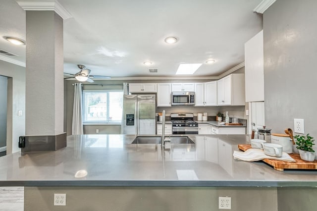 kitchen with white cabinetry, crown molding, stainless steel appliances, and kitchen peninsula