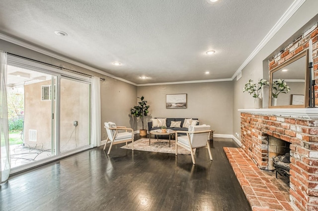 living room featuring hardwood / wood-style floors, crown molding, a fireplace, and a textured ceiling