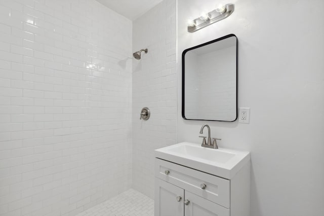 bathroom with vanity and a tile shower