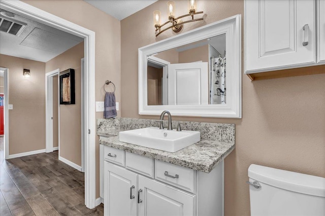 bathroom featuring hardwood / wood-style flooring, vanity, and toilet