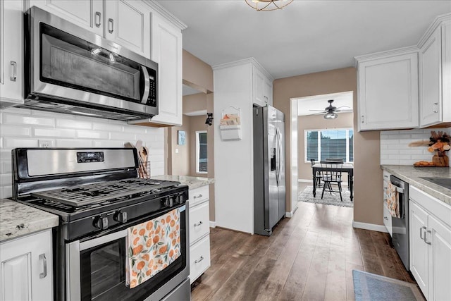 kitchen with appliances with stainless steel finishes, dark hardwood / wood-style floors, white cabinetry, and ceiling fan