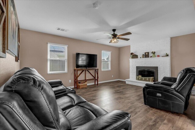 living room featuring a fireplace, ceiling fan, and dark hardwood / wood-style flooring