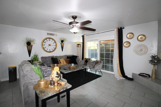 living room featuring visible vents, ceiling fan, and baseboards