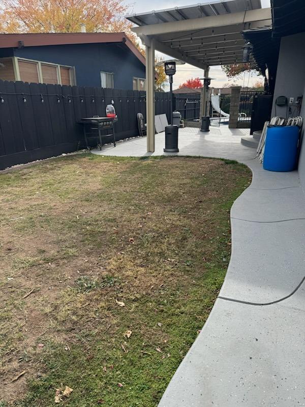 view of yard featuring fence and a patio