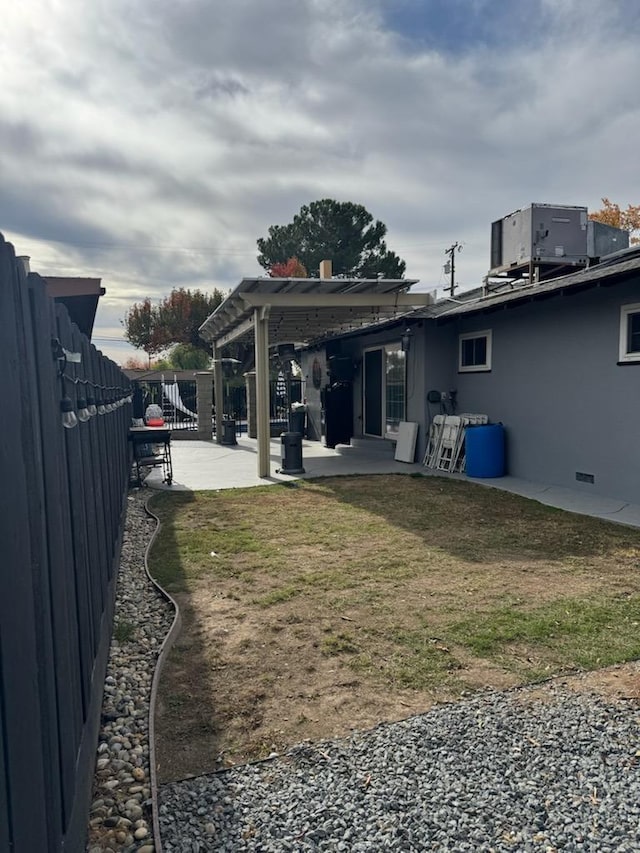 view of yard featuring a patio, central AC unit, and a fenced backyard