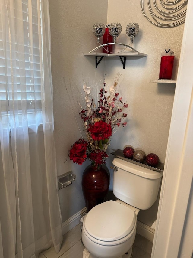 bathroom featuring baseboards, toilet, and tile patterned floors