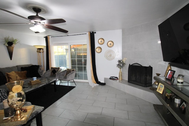 living room with light tile patterned floors, a ceiling fan, and a tile fireplace