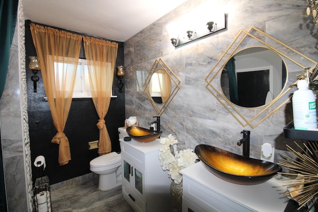 bathroom with toilet, tile walls, and vanity