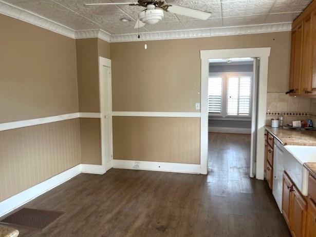 kitchen with dark hardwood / wood-style flooring, tasteful backsplash, ornamental molding, ceiling fan, and dishwasher