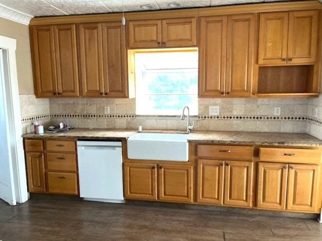 kitchen featuring backsplash, white dishwasher, and sink