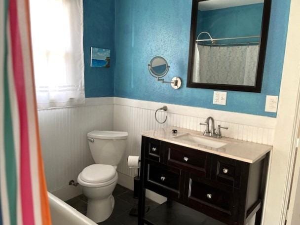 bathroom featuring tile patterned floors, vanity, toilet, and walk in shower