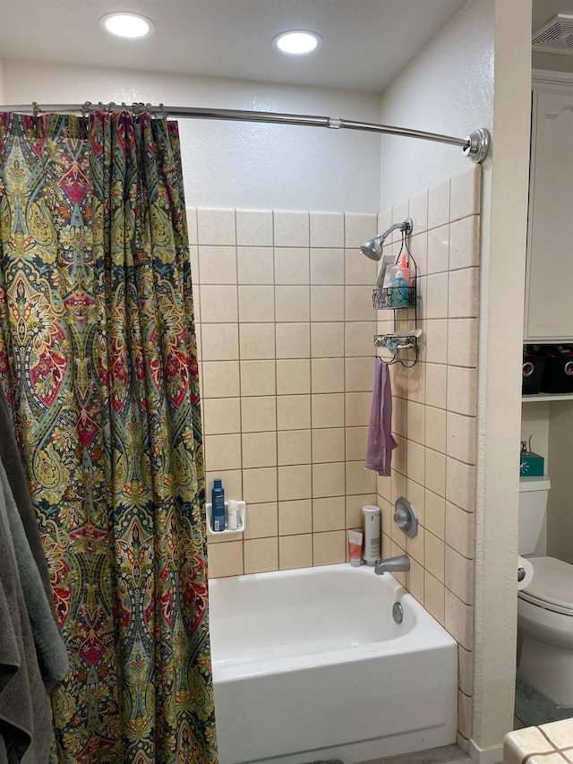 bathroom with shower / bath combination with curtain and toilet