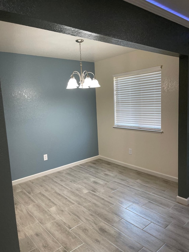 spare room with a chandelier and light hardwood / wood-style flooring