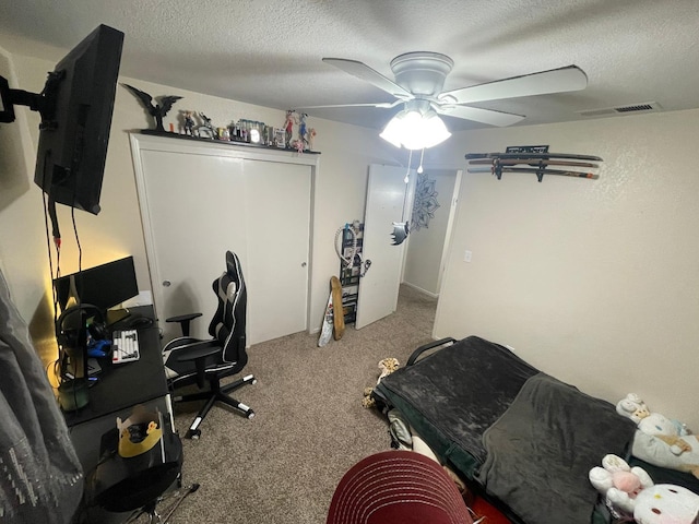 office featuring light carpet, ceiling fan, and a textured ceiling