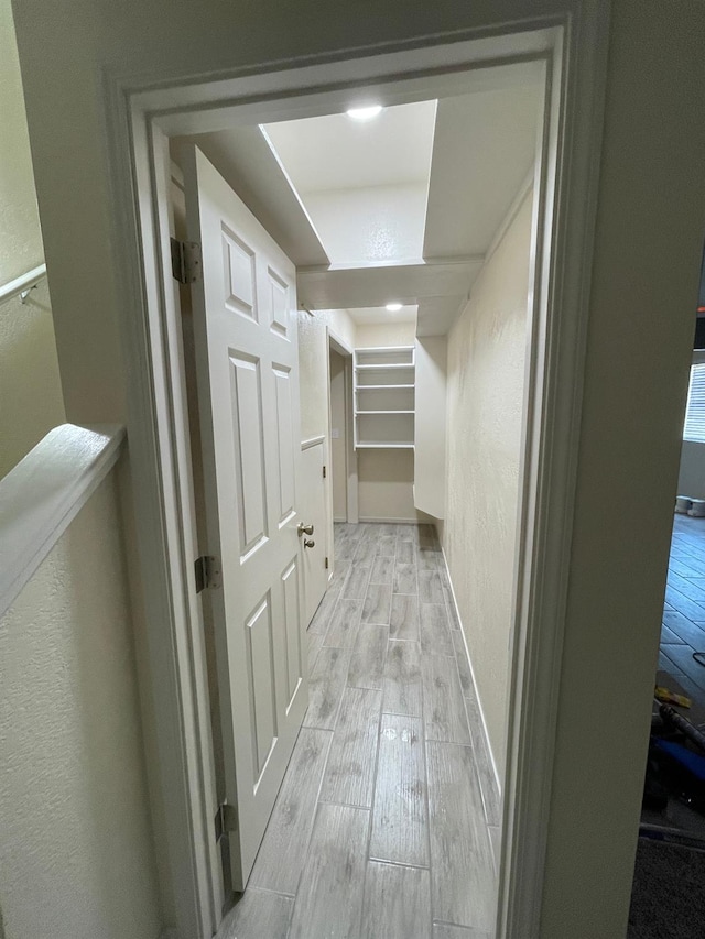 hallway with light hardwood / wood-style floors