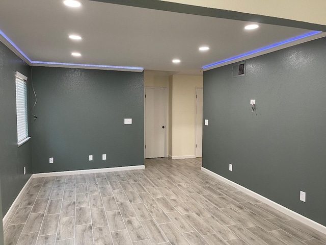 spare room featuring crown molding and light hardwood / wood-style flooring