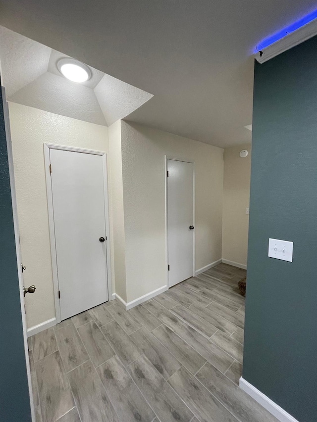 interior space featuring light hardwood / wood-style floors and vaulted ceiling