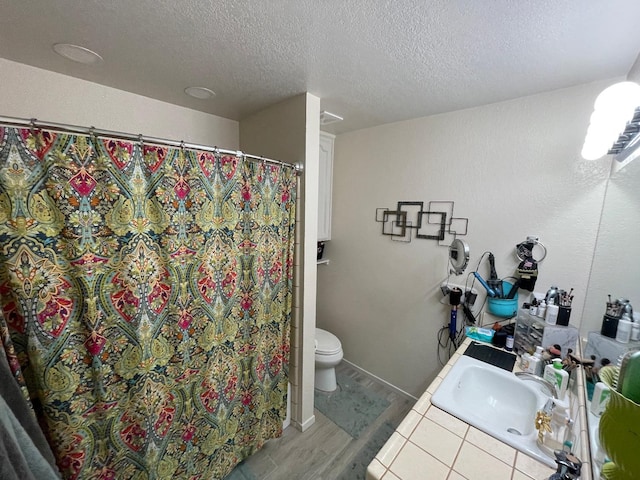 bathroom with hardwood / wood-style floors, vanity, a textured ceiling, and toilet