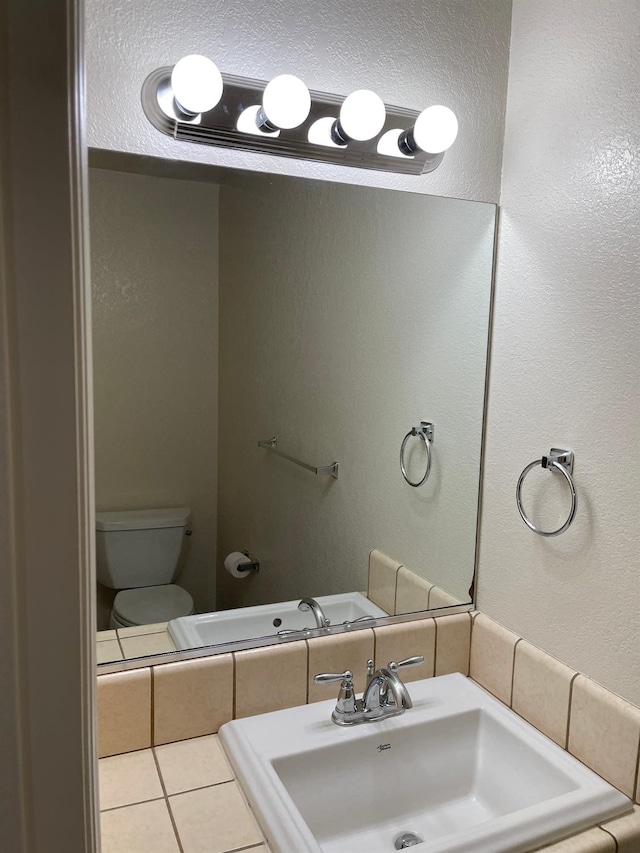 bathroom with tile patterned floors, sink, and toilet