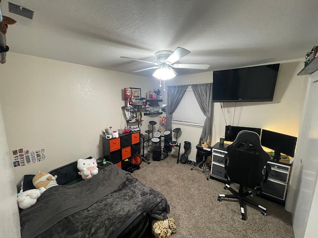 carpeted bedroom featuring ceiling fan and a textured ceiling