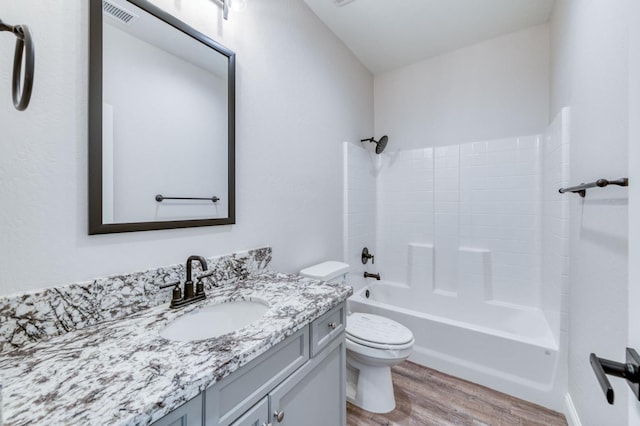 full bathroom featuring hardwood / wood-style floors, vanity, tub / shower combination, and toilet