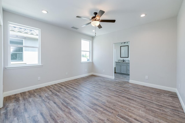 empty room featuring ceiling fan, sink, and hardwood / wood-style flooring