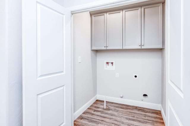 laundry area featuring cabinets, hookup for an electric dryer, light hardwood / wood-style flooring, gas dryer hookup, and hookup for a washing machine