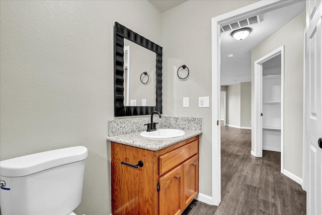 bathroom featuring vanity, hardwood / wood-style flooring, and toilet