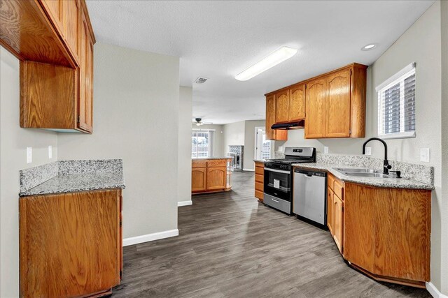 kitchen with sink, dark hardwood / wood-style floors, ceiling fan, a textured ceiling, and stainless steel appliances