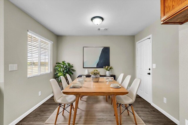 dining space with dark hardwood / wood-style floors