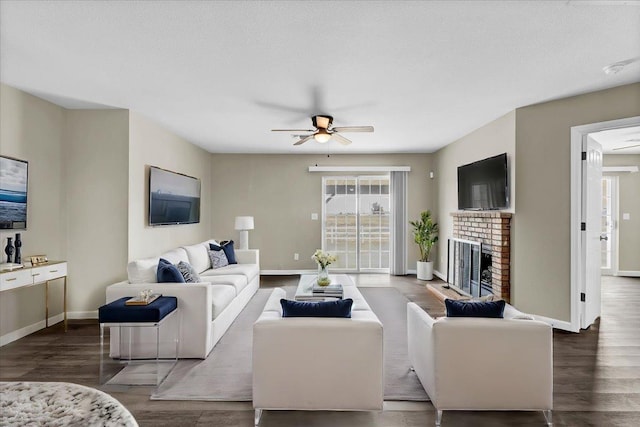 living room with a fireplace, a textured ceiling, dark hardwood / wood-style floors, and ceiling fan