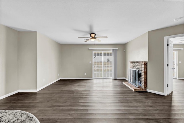 unfurnished living room with a textured ceiling, a fireplace, ceiling fan, and dark wood-type flooring