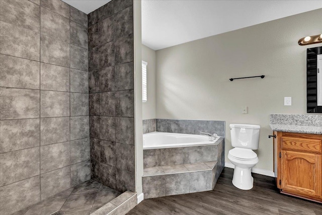 bathroom featuring vanity, toilet, wood-type flooring, and tiled tub