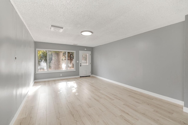 empty room featuring light hardwood / wood-style floors and a textured ceiling