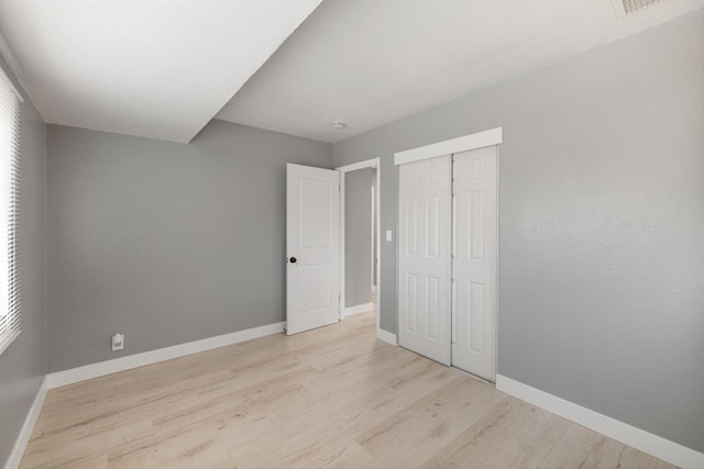 unfurnished bedroom with light hardwood / wood-style floors and a closet