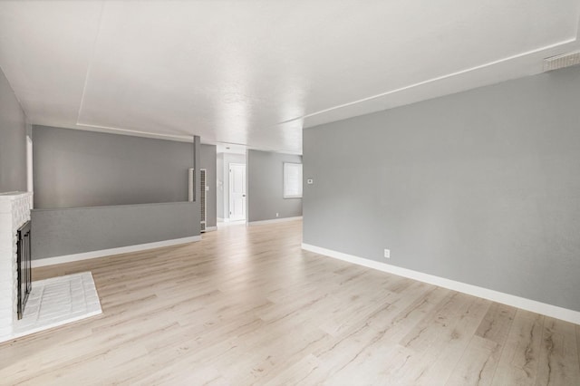 unfurnished living room with a fireplace and light hardwood / wood-style floors