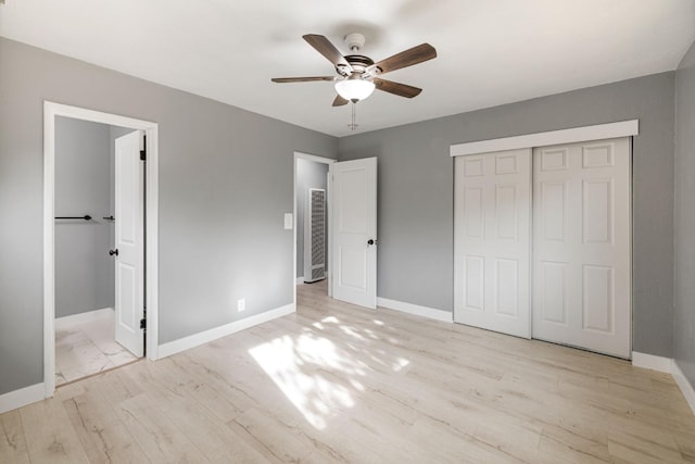 unfurnished bedroom featuring ceiling fan, a closet, and light hardwood / wood-style flooring