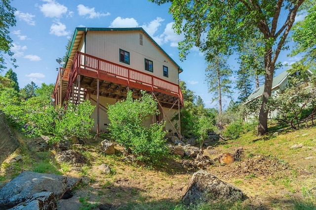 rear view of property featuring a deck and stairs