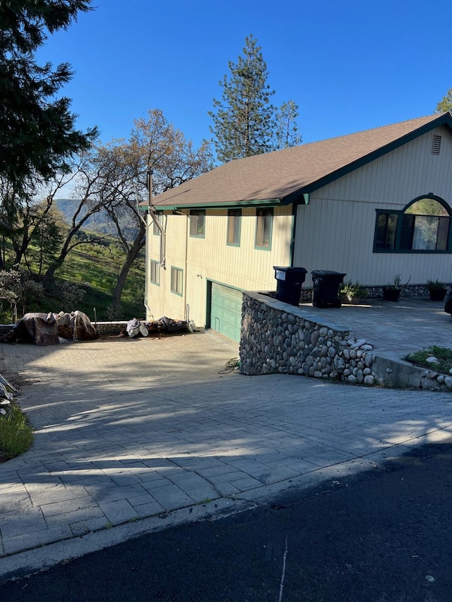 view of side of property featuring an attached garage and concrete driveway