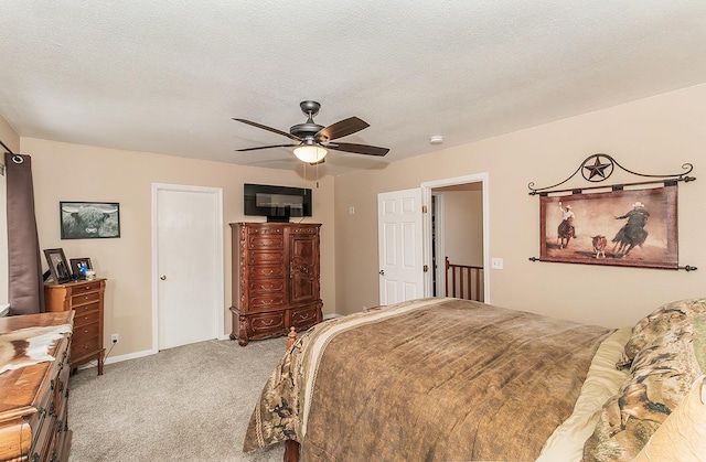 bedroom with a ceiling fan, carpet, and a textured ceiling