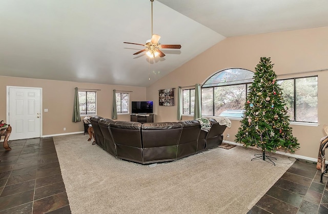 living room with a ceiling fan, lofted ceiling, and baseboards