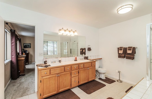 bathroom with double vanity, a stall shower, toilet, tile patterned floors, and a sink